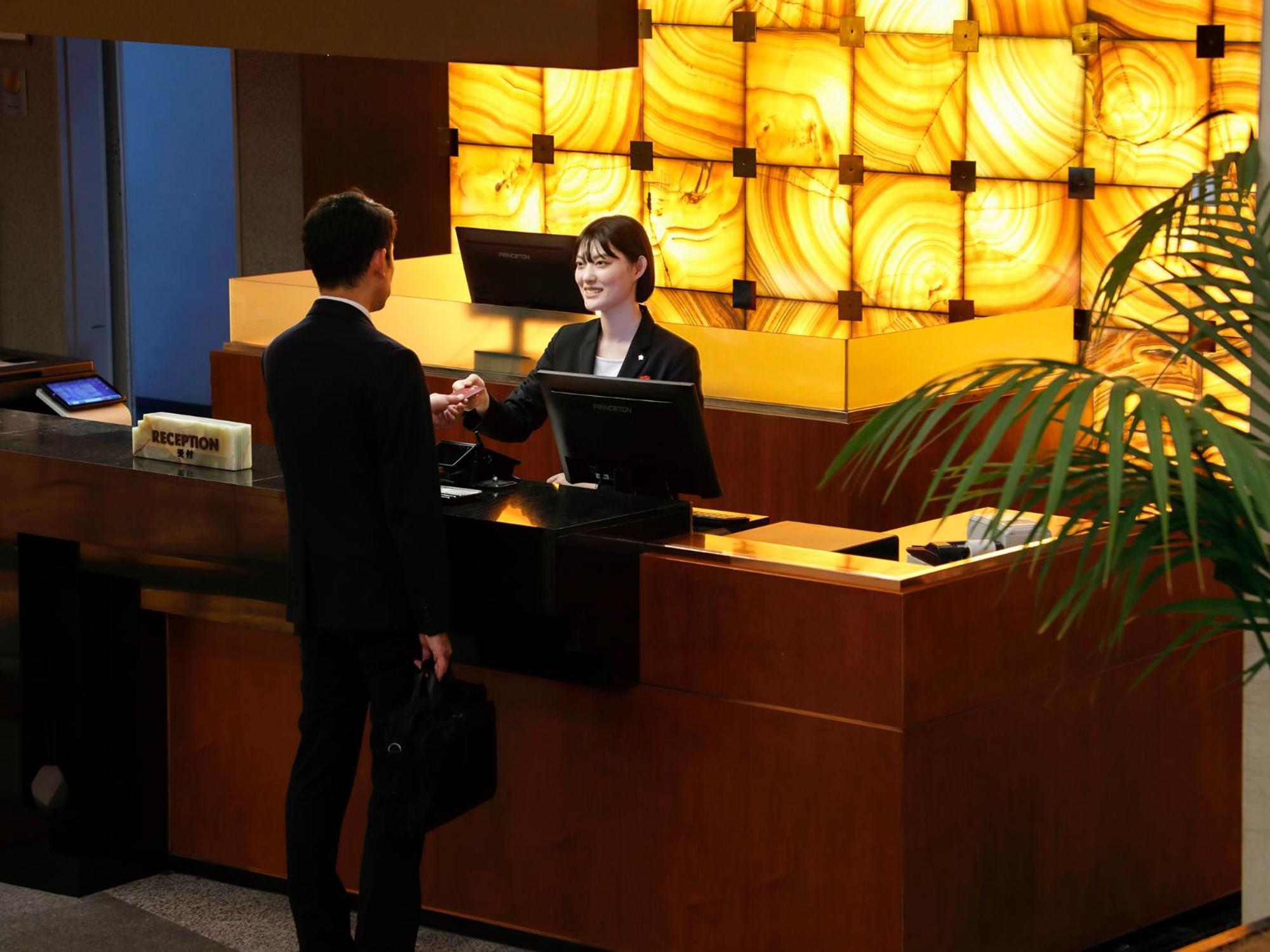 Premier Hotel -Tsubaki- Sapporo Esterno foto A hotel receptionist at work